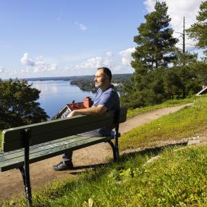 Rosario Fina is sitting on a bench in late summer 2026.