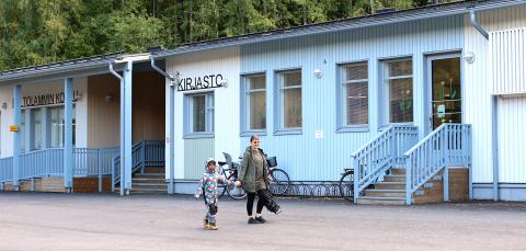 Lapsi ja äiti kävelemässä Peltolammin kirjastosta.