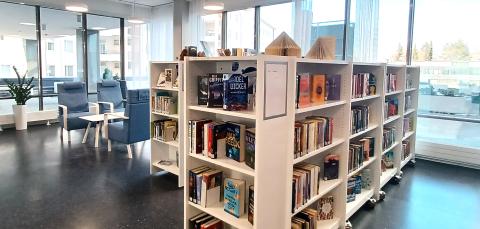 Koukkuniemen kirjaston pöytäryhmä ja kirjahyllyjä.