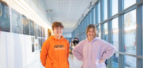 Kaksi nuorta seisoo lukion lasiseinäisellä käytävällä.