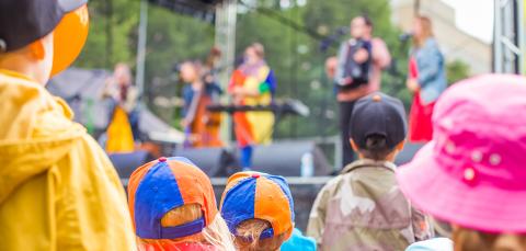 Lapset katsovat ulkolavalla esiintyvää yhtyettä.