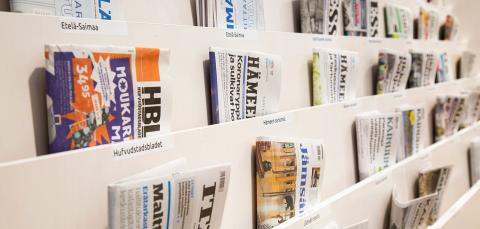 Sanomalehtiä hyllyssä.