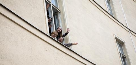 Tampereen lyseon lukion opiskelijoita heiluttaa koulun ikkunasta.
