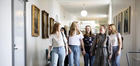 Tampereen lyseon lukion opiskelijoita kävelee koulun käytävällä.