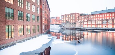 Tampereen vanhat punatiiliset tehdasrakennukset jäisen Tammerkosken rannalla.
