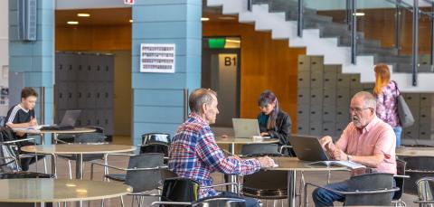 Aikuislukion aulassa tapaat muita opiskelijoita ennen oppitunteja.