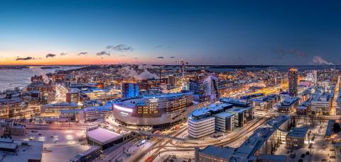 Tunnelmallinen ilmakuva Tampereen keskustasta iltavalaistuksessa. Etualalla Nokia Arena.