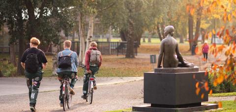 Haalareihin pukeutuneita pyöräilijöitä puistossa.