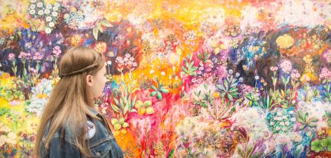 Nuori katselee taidemaalausta Sara Hildénin taidemuseossa.