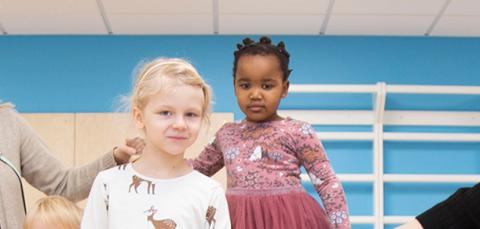 Kaksi aikuista ja kaksi lasta päiväkodissa.