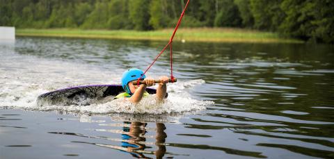 Wakeboardin harrastaja vedessä.