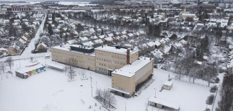 Nekalan vanha koulurakennus kuvattuna ilmasta talvisena päivänä.