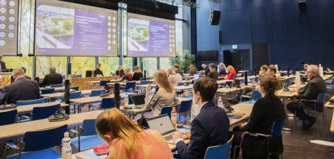 Tampereen kaupunginvaltuusto istuu kokouksessaan Tampere-talossa. Salin edessä on kolme suurta näyttöä.