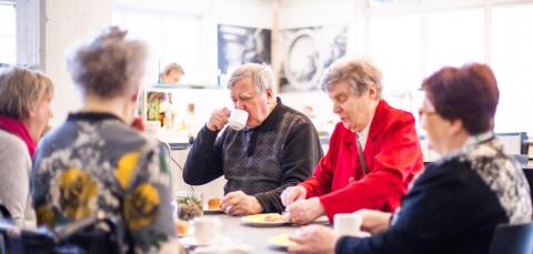 A group of elderly people having coffee.