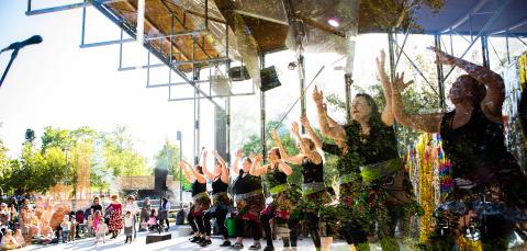 Tanssijoita liehuvat hameet päällä ja kädet ilmassa esiintymässä Laikunlavalla.