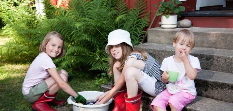 Kolme lasta leikkimässä rappusilla.