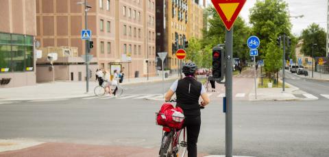 Pyöräilijä odottaa liikennevalojen vaihtumista Rongankadulla.