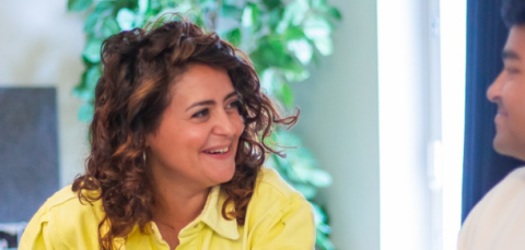 Kaksi henkilöä keskustelemassa iloisesti vierekkäin.