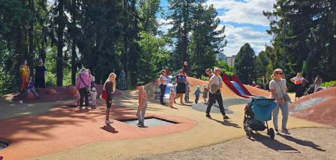 Lapsia ja aikuisia Tiitiäisen satupuiston kumpareilla.