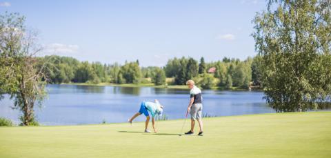 Kaksi golfaajaa kentällä.