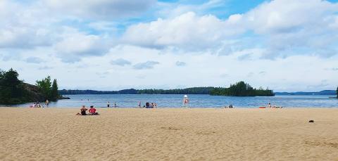 Auringonottajia Pyynikin hiekkarannalla.