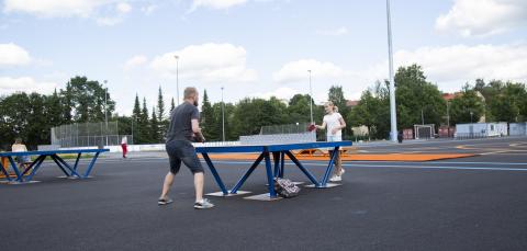 Vanhempi ja nuori pelaavat pöytätennistä Kaupin urheilupuistossa.