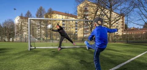 Poika potkimassa palloa maaliin 