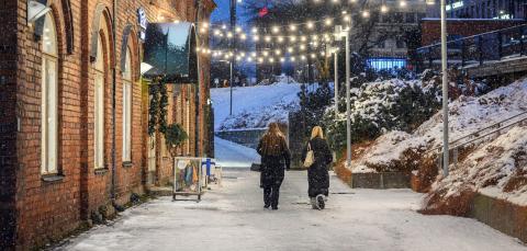 Two people are walking under the lights.