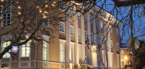 Keltainen iso rakennus hämärässä valaistuksessa talvella.