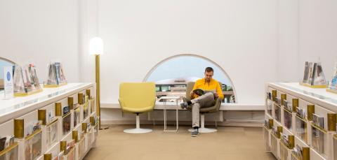 Metson lehtisali. Taustalla henkilö istuu nojatuolissa ja lukee lehteä. 