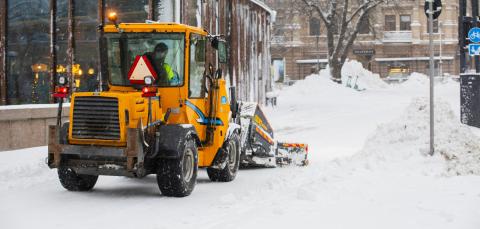 Auraustraktori lumitöissä keskustassa takaapäin kuvattuna.
