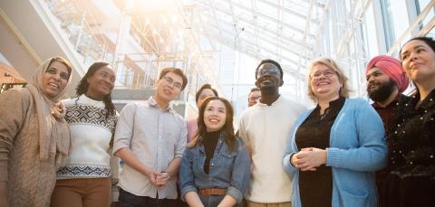 Iso joukko hymyileviä, eri kulttuureista lähtöisin olevia tamperelaisia rinnakkain.