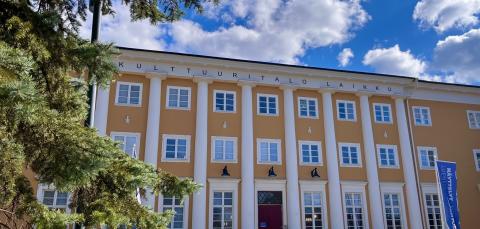 Kulttuuritalo Laikku keväisessä auringonpaisteessa, taustalla sininen taivas ja pilvenhattaroita.