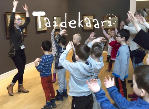 Lapset nostavat käsiään museokierroksella.