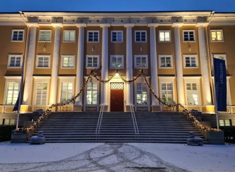 Keltainen iso rakennus hämärässä valaistuksessa talvella.