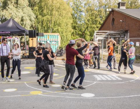 Joukko ihmisiä tanssii Hiedanrannassa.