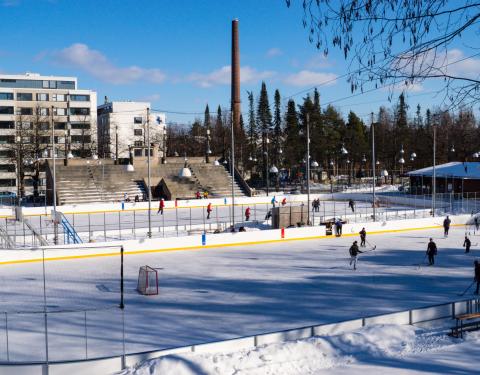  The ice rink is photographed from above. On the ice, players with sticks in their hands.