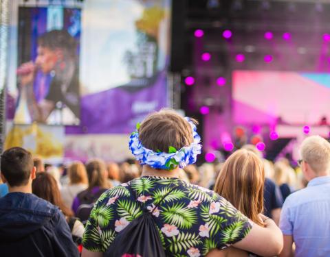 Etualalla yleisöä ja taaempana Tammerfestin lava, joka on valaistu violeteilla valoilla.