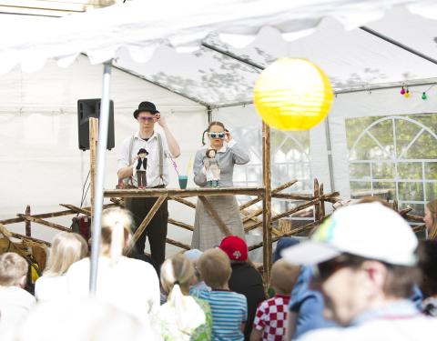 Mies ja nainen esiintymässä käsissään nuket.