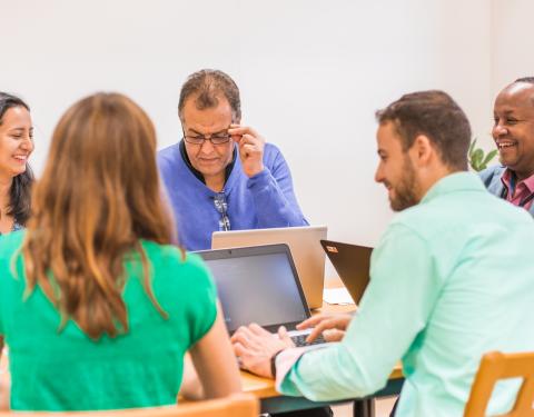 Ihmisiä pöydän ääressä