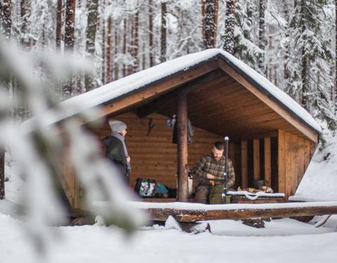 Retkeilijöitä laavulla talviaikaan