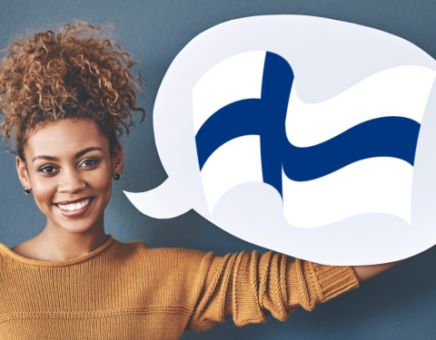 Nainen pitelee puhekuplaa, jossa on Suomen lippu.