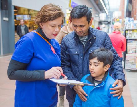 Kaupungin työntekijä keskustelee tamperelaisen ja hänen lapsensa kanssa.