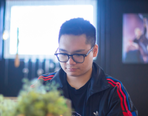 Nuori mies istuu tietokoneen äärellä.