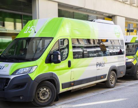 Pali palveluliikenteen kaksi bussia pysäköitynä peräkkäin kadulla.