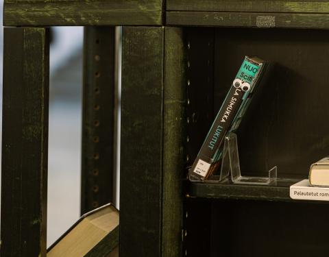 Kirjahyllyssä kirja, jolla on silmät.