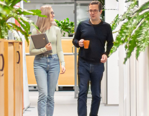 Mies ja nainen kävelevät toimistossa.