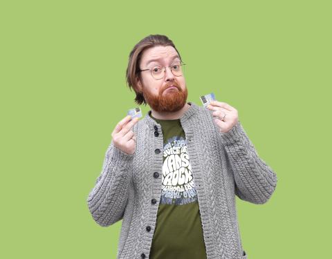 Henkilö pitää käsissään rikkinäisen kirjastokortin palasia.