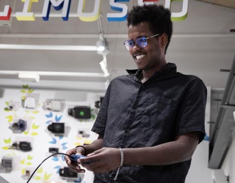 Henkilö pelaa pelikonsolilla Vapriikin pelimuseossa.