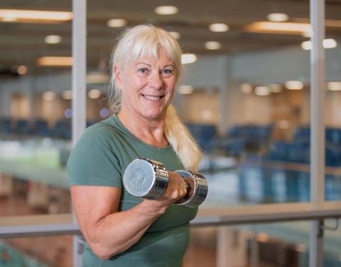 Iloinen nainen käsipaino kädessä 